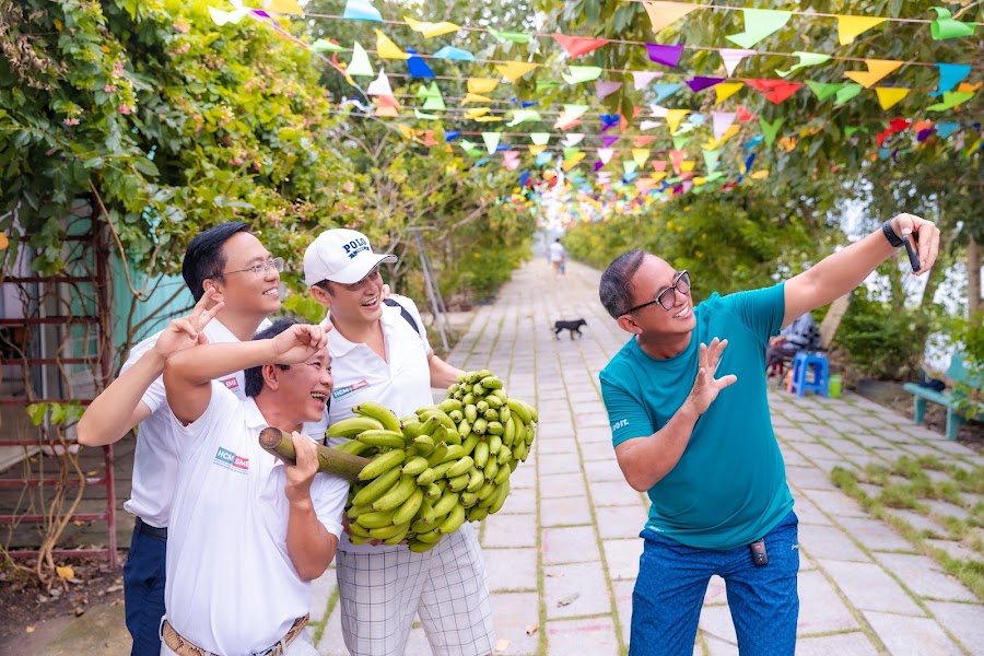 Nhóm khách vui vẻ bên buồng chuối vừa thu hoạch