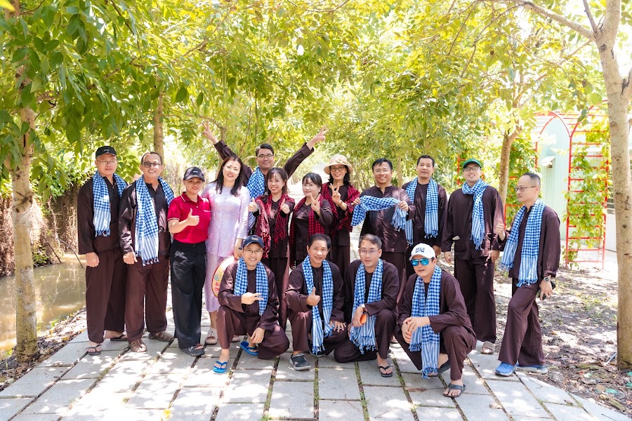 Đoàn khách chụp ảnh lưu niệm trên lối đi cây xanh tại Nông trại Thiên Đường